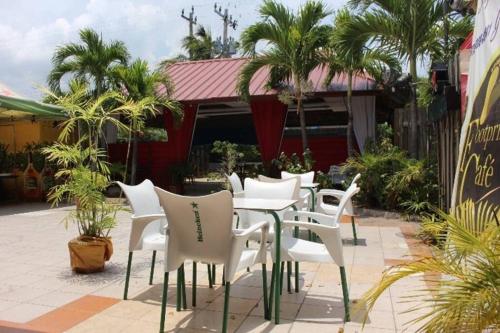 a group of white chairs and tables on a patio at The Mango Lodge in Kingston
