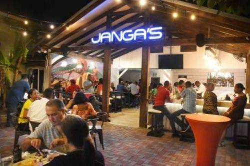 a group of people eating food in a restaurant at The Mango Lodge in Kingston