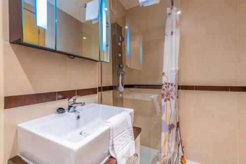 La salle de bains est pourvue d'un lavabo et d'une douche. dans l'établissement Vacaciones Oromarina Jardines del Mar, à Oropesa del Mar