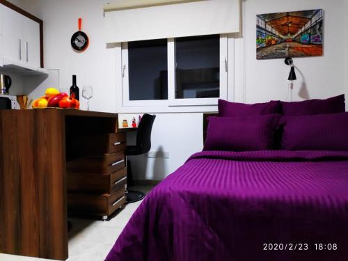 a bedroom with a purple bed and a dresser at RiX Studio Park Famagusta Contactless Check In & Check Out in Mağusa