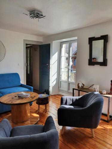 a living room with a blue couch and a table at BEL APPARTEMENT LUCHON CENTRE WIFI - CLIMATISATION 6 COUCHAGES in Luchon