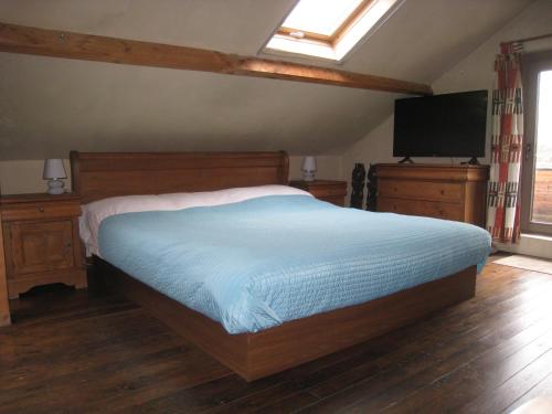 a bedroom with a bed and a flat screen tv at Vakantiehuis in de velden met zwemvijver en Jeu de Boules baan in Lier