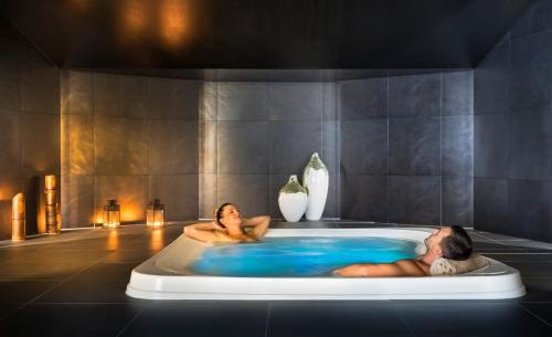a man and woman laying in a bath tub at Aminess Maestral Hotel in Novigrad Istria