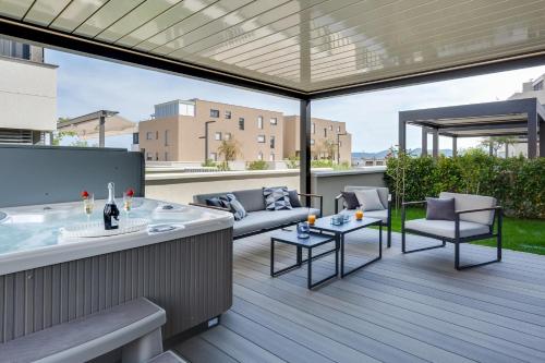 a patio with a hot tub on a deck at Shell Luxury Residences with Pool and Whirlpool in Zadar