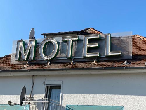 ein Neonschild auf dem Dach eines Gebäudes in der Unterkunft Motel Herbold in Knüllwald