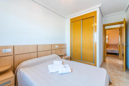 - une chambre avec un lit et 2 serviettes dans l'établissement Vacaciones Oromarina Jardines del Mar, à Oropesa del Mar