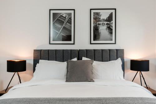 a bedroom with a bed with three pictures on the wall at Tailored Stays - Flamsteed Duplex Apartment in Cambridge