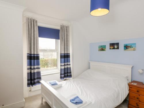a bedroom with a white bed and a window at 49 Ulwell Road in Swanage