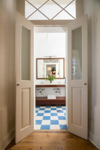 a hallway with a bathroom with a sink and a mirror at Casa de Mogofores in Anadia