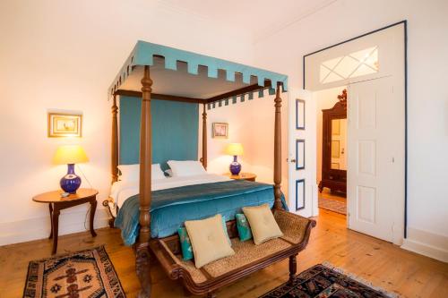 a bedroom with a canopy bed and a wooden floor at Casa de Mogofores in Anadia