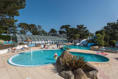 - une piscine dans un complexe avec des personnes dans l'établissement Camping Le Moténo - Maeva, à Plouhinec