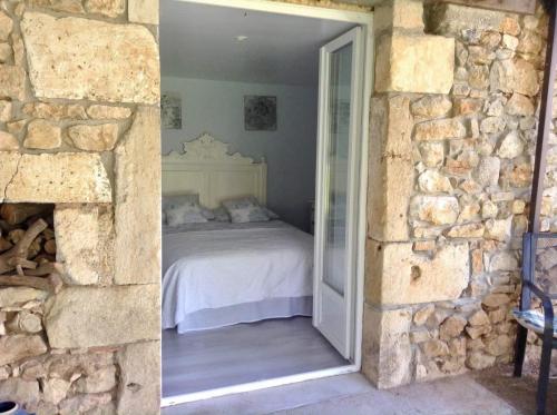 sypialnia z łóżkiem w kamiennej ścianie w obiekcie The Gatehouse at the old forge w mieście Feuillade
