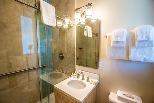 uma casa de banho com um lavatório, um chuveiro e um espelho. em Hilltop Villas at Bluebeard's Castle by Capital Vacations em Charlotte Amalie