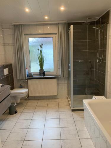 a bathroom with a tub and a toilet and a window at Andrea-EG in Büsum