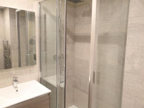 une salle de bain avec une douche en verre et un lavabo dans l'établissement HYPER-CENTRE MODERNE APPART 206, à Nice