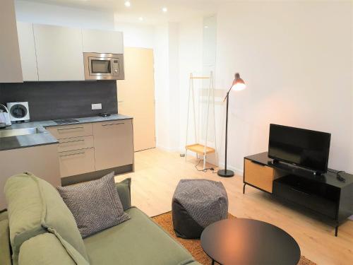 un salon avec un canapé et une table et une cuisine dans l'établissement HYPER-CENTRE MODERNE APPART 206, à Nice