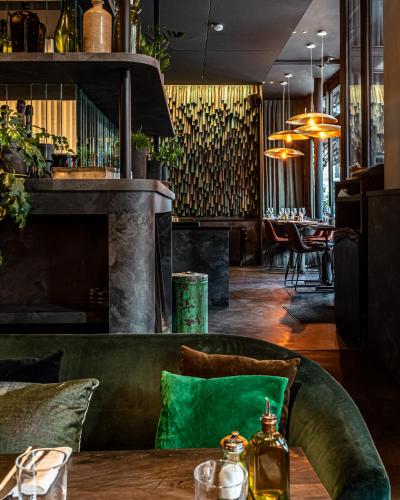 a dining room with a table with a green couch at Hôtel National Des Arts et Métiers in Paris