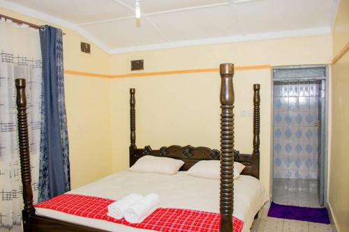- une chambre dotée d'un lit avec une couverture rouge et blanche dans l'établissement Ol marei Home, à Nanyuki