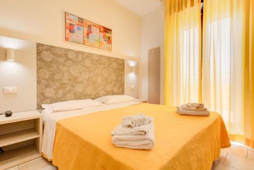 a hotel room with a bed with towels on it at Hotel Reyt in Rimini