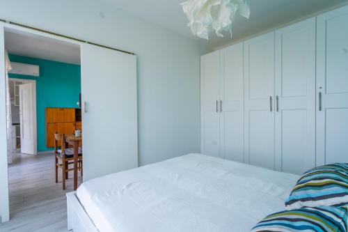 ein weißes Schlafzimmer mit einem Bett und einem Tisch in der Unterkunft Casa di Annika - Vista Laguna e Parcheggio privato in Grado