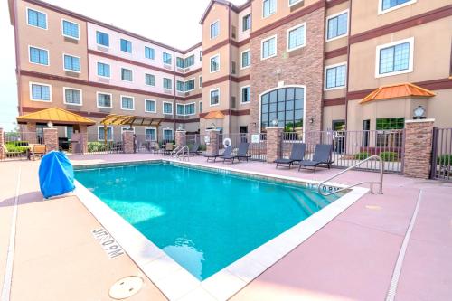 a swimming pool in front of a apartment building at Staybridge Suites Houston - IAH Airport by IHG in Houston
