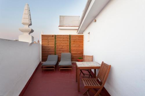 d'une terrasse avec des bancs, une table et des chaises. dans l'établissement Petit Palace Puerta de Triana, à Séville
