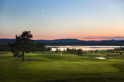 a view of a golf course with a lake at Hotell Veckefjärden in Örnsköldsvik