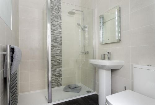 W łazience znajduje się prysznic, umywalka i toaleta. w obiekcie Millstone Cottage w mieście Bourton-on the-Water