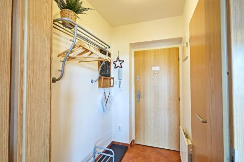 um quarto com um corredor com uma porta e uma mesa em Apartmán Klínovec 365 em Loučná pod Klínovcem