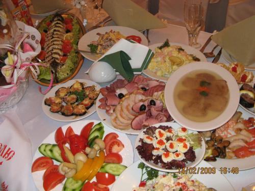 a table with many plates of food on it at Hotel Mirage in Sudovaya Vishnya