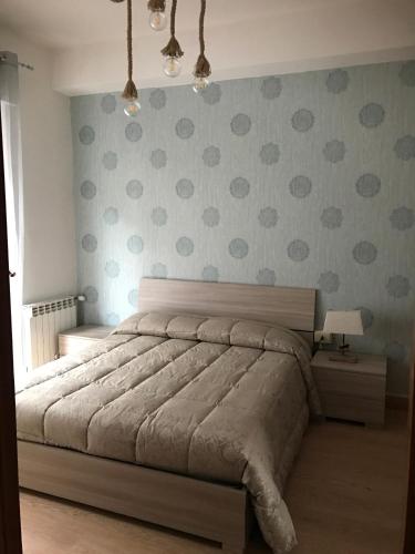 ein Schlafzimmer mit einem Bett mit Tupfen an der Wand in der Unterkunft BITERVO in Viterbo