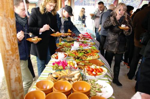 a group of people standing around a table with food at Hotel Mirage in Sudovaya Vishnya