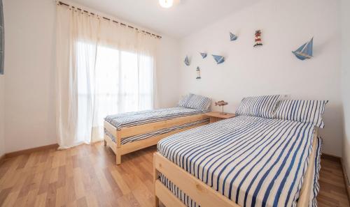 Duas camas num quarto com uma janela em TarracoHomes, Beach apartment cambrils em Cambrils