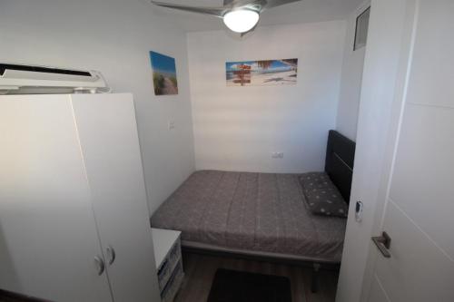 um pequeno quarto com uma cama num quarto em Przytulny Apartament z widokiem na morze !!!!! em La Mata