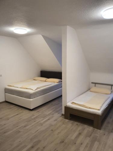 two beds are in a room with at Gasthaus Neue Mühle in Kassel