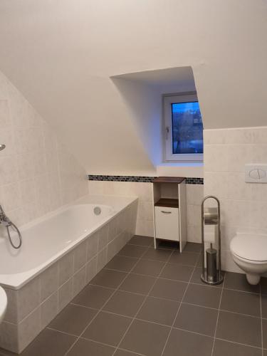 a bathroom with a tub and a toilet and a sink at Gasthaus Neue Mühle in Kassel