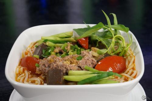 a white bowl of food with noodles and vegetables at Khách Sạn Thiên Trí Lý Sơn in Ly Son