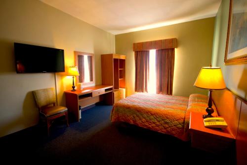 Un pat sau paturi într-o cameră la Hotel Consulado Inn