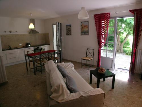un salon avec un canapé blanc et une table dans l'établissement Au charme et à la campagne, à Avignon