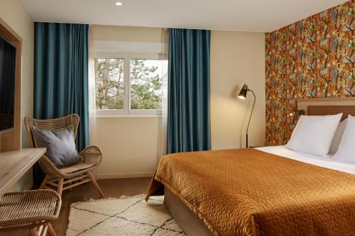 a hotel room with a bed and a window at Les Nomades Beaune in Beaune