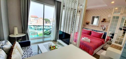 a living room with a red couch and a large window at Sweet Seaview flr6 with toproop pool flr7 at The BluX Bangsaen in Ban Bang Saen (1)