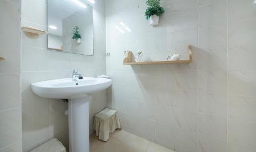 uma casa de banho branca com um lavatório e um espelho em TarracoHomes, Beach apartment cambrils em Cambrils