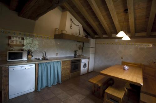 a kitchen with a wooden table and a counter top at La Fuente del Poval in Caballar