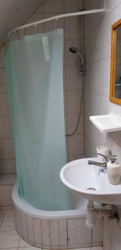 a bathroom with a white sink and a shower at Vila Kamila in Tatranska Strba