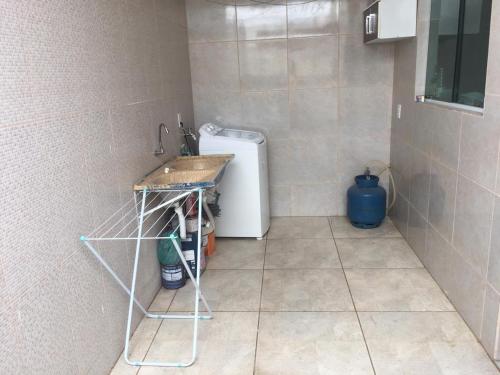 a laundry room with a sink and a washing machine at Aconchego na Capital do Forró in Caruaru