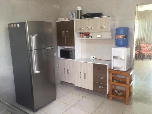 a kitchen with a stainless steel refrigerator and cabinets at Aconchego na Capital do Forró in Caruaru
