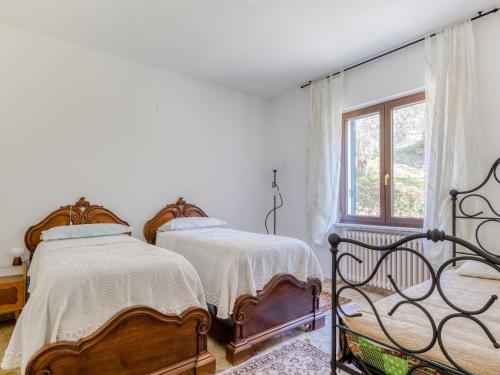2 camas en una habitación blanca con ventana en Belvilla by OYO La Rosa dei Venti en Erli