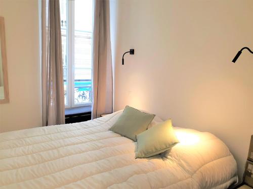 - une chambre avec un lit avec deux oreillers et une fenêtre dans l'établissement HYPERCENTRE/LAMARTINE APPARTEMENT 106, à Nice