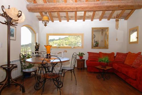 salon z czerwoną kanapą i stołem w obiekcie La maison jaune w mieście La Roque-sur-Pernes