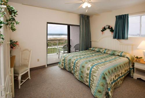 um quarto de hotel com uma cama e uma varanda em Lotus Inn em Wildwood Crest